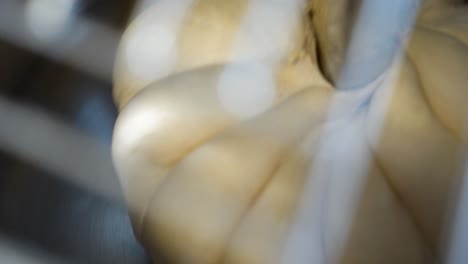 industrial mixer kneading bread dough, close-up view