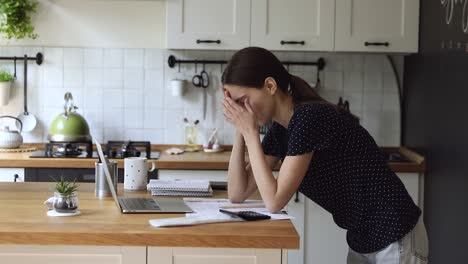 woman makes expense and earnings analysis feels tired and disappointed