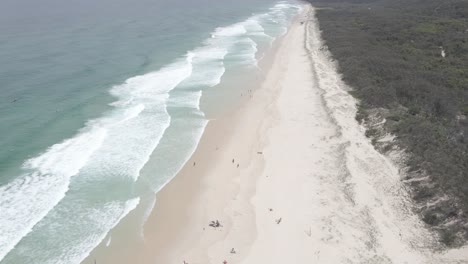 Playa-De-Arena-Con-Turistas-Disfrutando-De-Las-Vacaciones-De-Verano-En-La-Playa-Principal---Point-Lookout,-Qld,-Australia