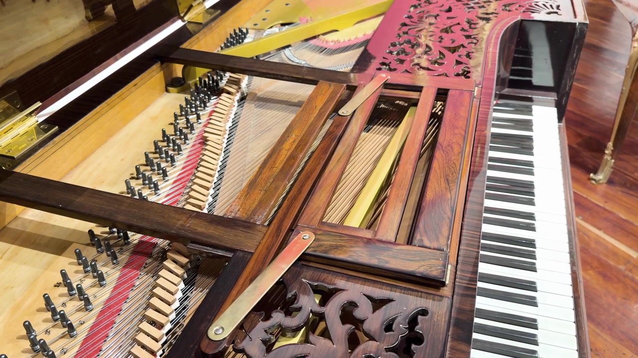 Primo piano dell'interno decorato e della tastiera di un pianoforte in un ambiente interno ben illuminato