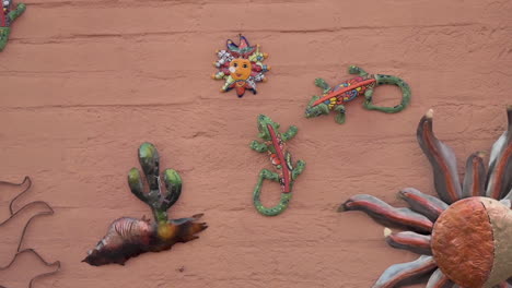 closeup view of mexican ceramic artwork hanging on the red brick wall in tubac, arizona usa