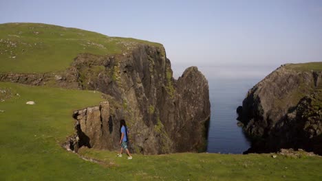 man walks on a cliff edge