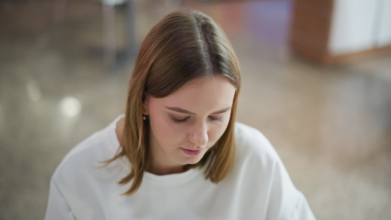 крупный план молодой женщины глубоко в мыслях, выглядящей созерцательно, с мягким освещением и размытым фоном, она кажется сосредоточенной и интроспективной