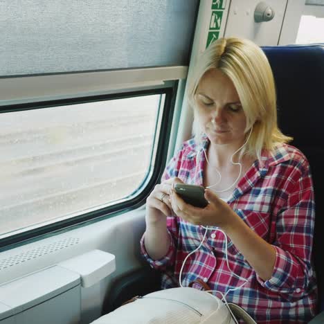 a woman is traveling on the second floor of a train sitting by the window