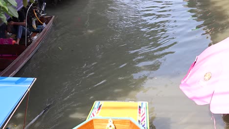 boats navigate a canal at a vibrant market