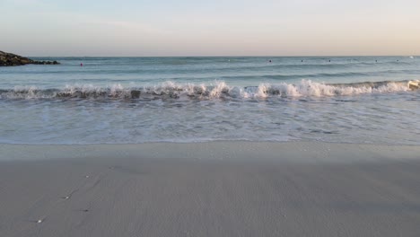 Drone-camera-view-of-waves-breaking-on-the-beach,-ocean-waves-crashing-and-foaming-against-the-empty-shore,-4k-Footage