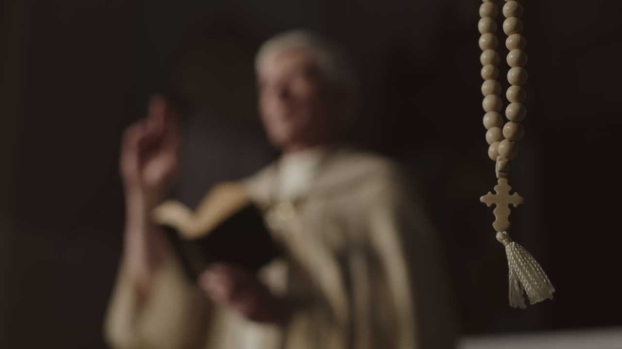Rosary Beads and Unrecognizable Clergyman Preaching on Background