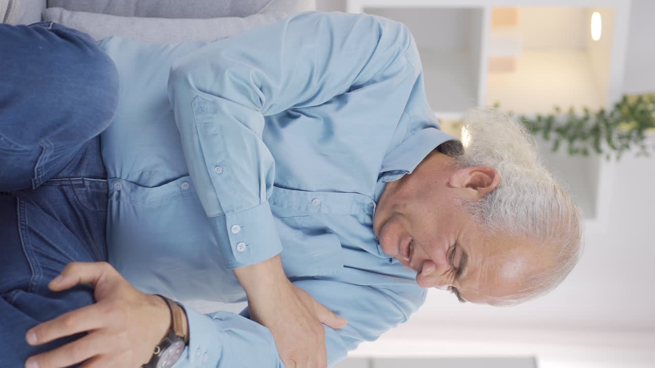 Vertical video of The old man is suffering from joint pain.