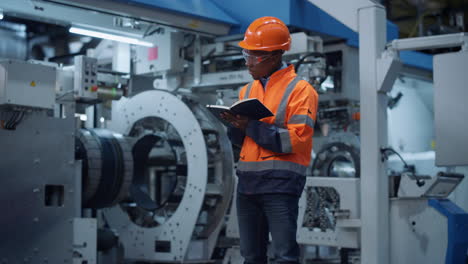 male engineer taking notes of project data at manufacturing factory.