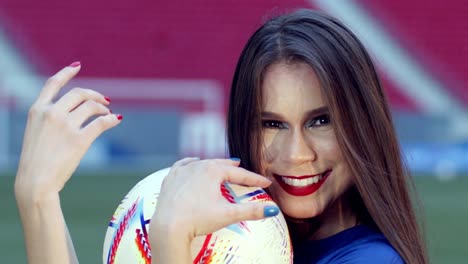 cute brazilian brunette smiles and plays with football