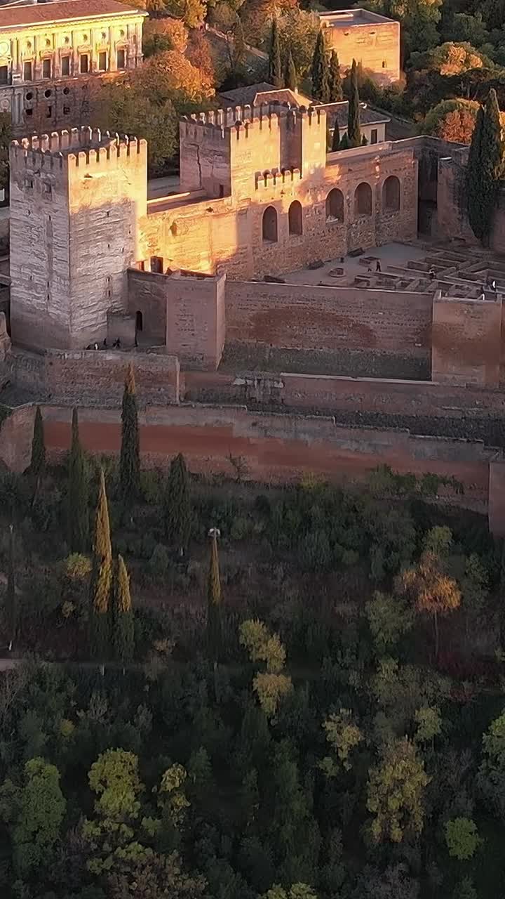 Vista da histórica Alhambra em Granada, Espanha, ao pôr do sol com árvores