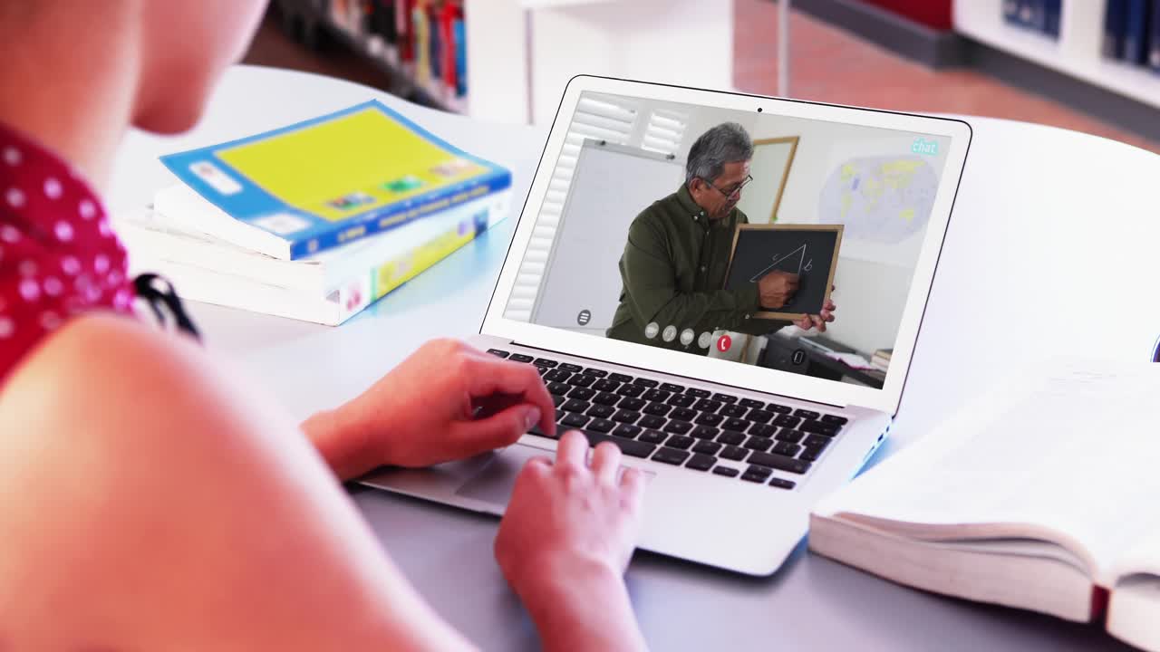 estudiante caucásica usando una computadora portátil en una videollamada con un profesor masculino