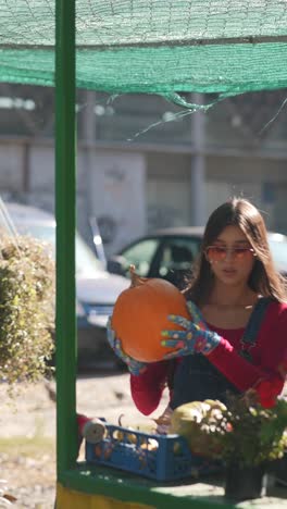 mujer con calabaza en un mercado al aire libre