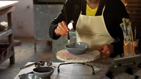 pintura de alfarero masculino atento en el cuenco