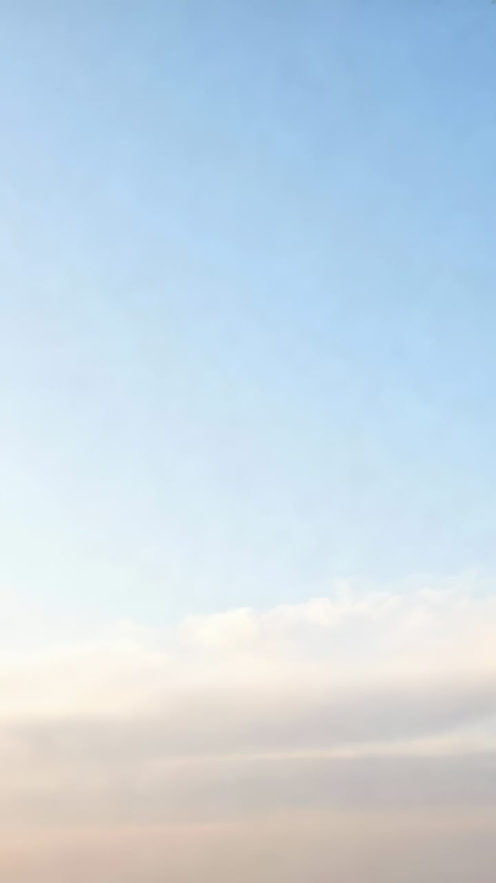 Vertical video: Filming sky shifting near horizon as frames advancing, capturing thin cloud band