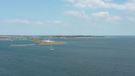 Drone---Aerial-shot-of-sailing-boats-on-a-blue,-wavy-and-windy-sea-on-a-sunny-day-with-white-clouds,-30p