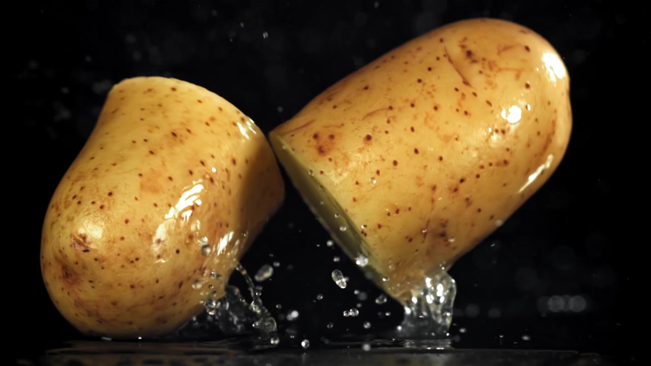 Al rallentatore di una patata tagliata che schizza nell'acqua.