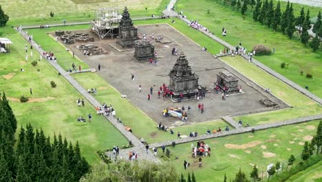 ancient stone temple surrounded by green meadows, aerial orbit view