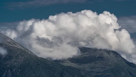 white fluffy clouds flowing over the mountains