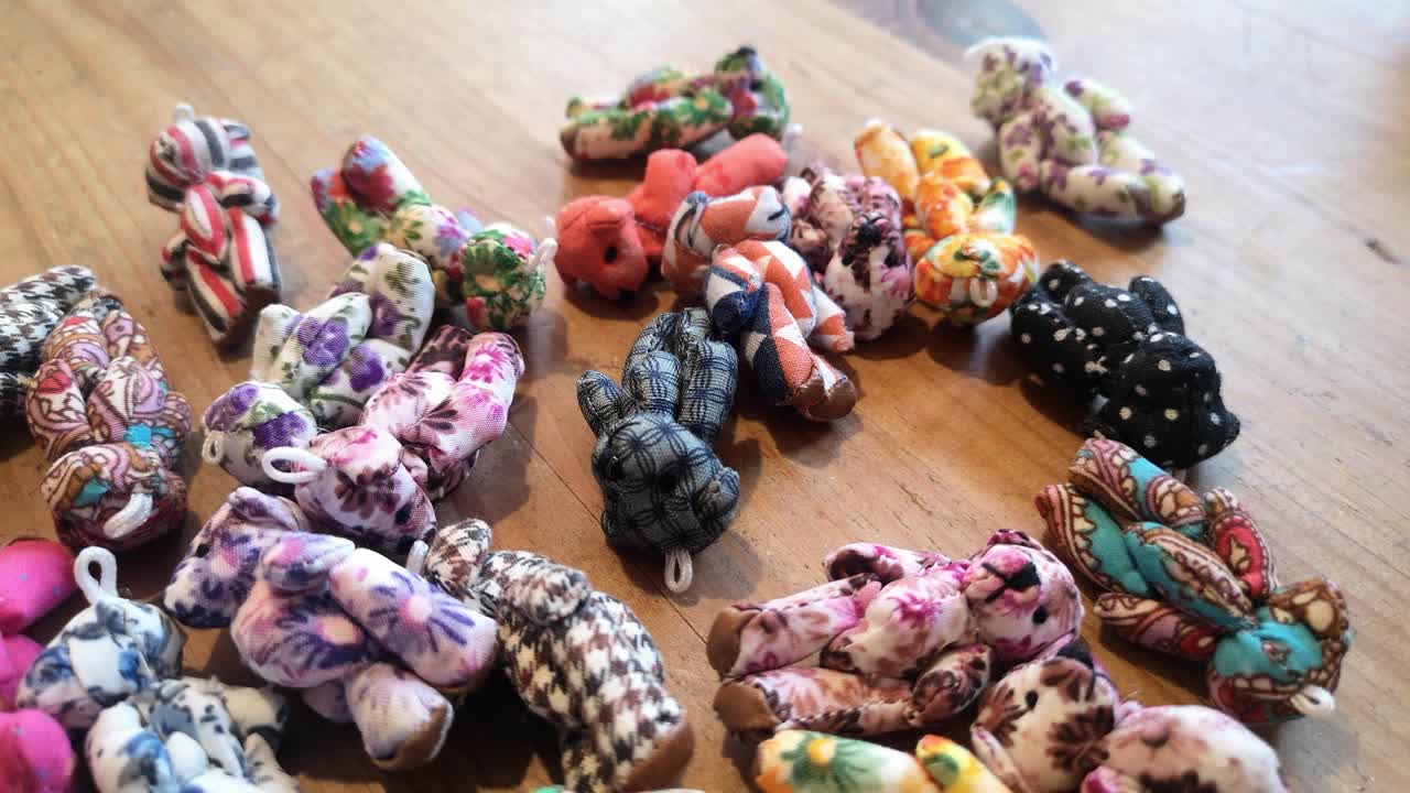 hechos a mano, coloridos y adorables osos de peluche de juguete estampados en miniatura, que caen sobre una mesa de madera