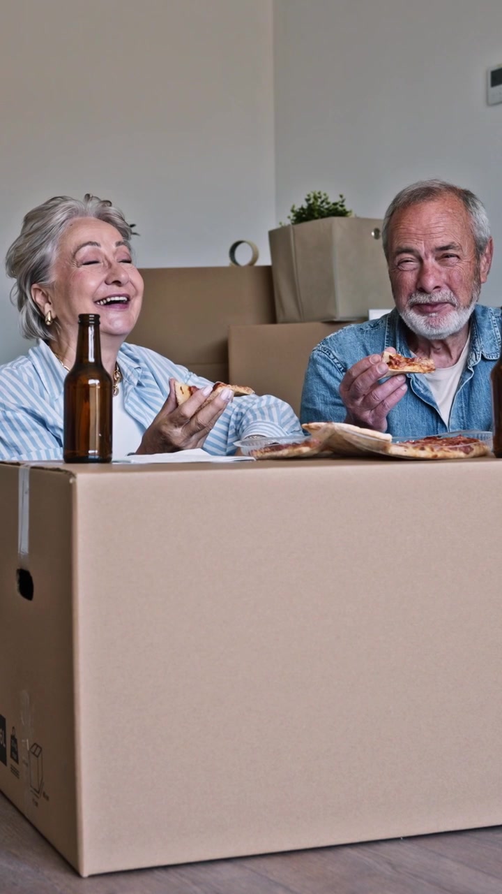 Happy Senior Couple Eating Pizza While Moving Into New Home