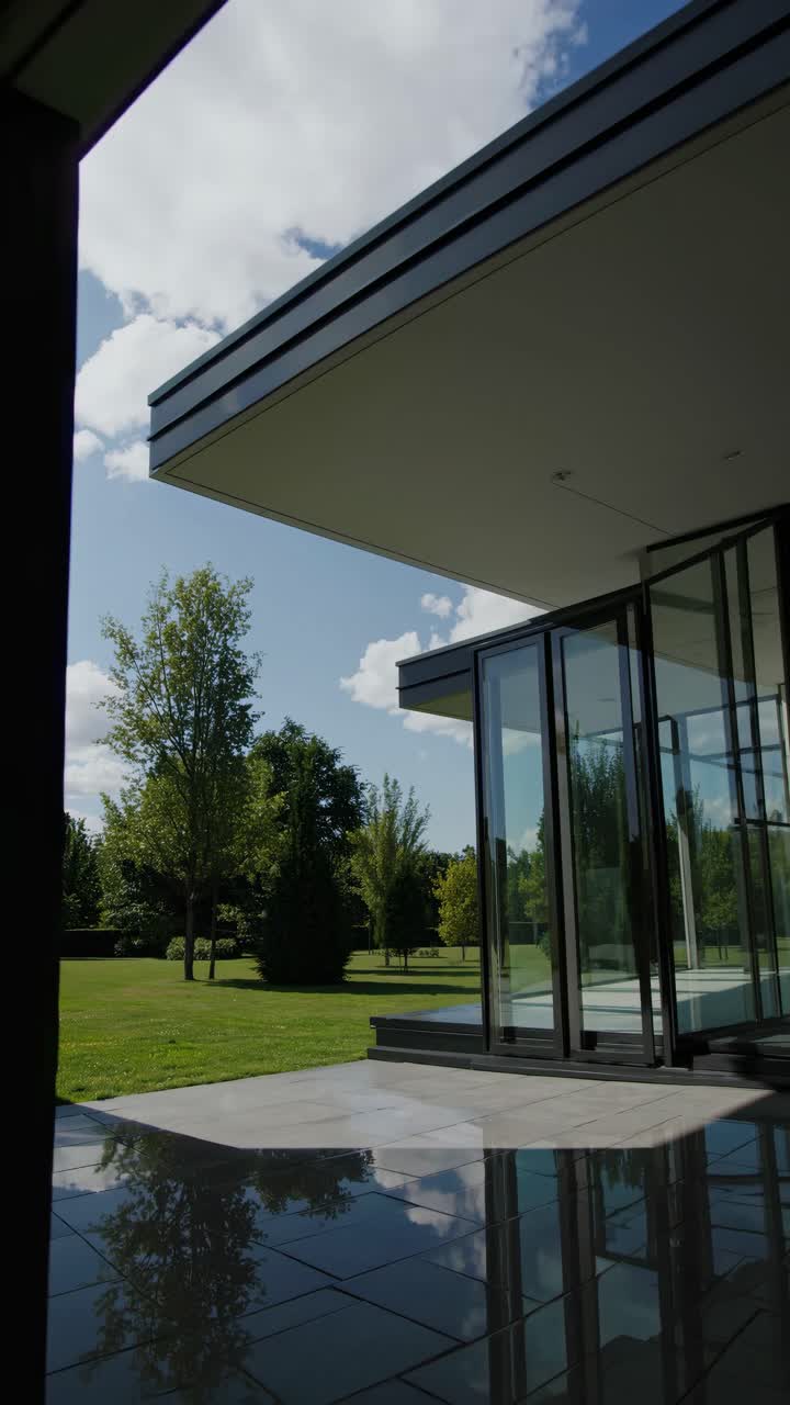 Modern architectural design with a low-angle view of a glass building, reflecting nature