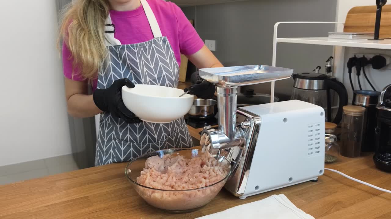 mujer preparando carne molida con un molinillo de carne