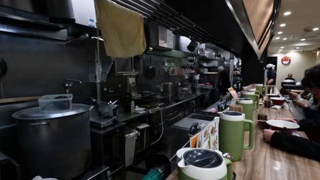 chef prepares ramen in a busy kitchen