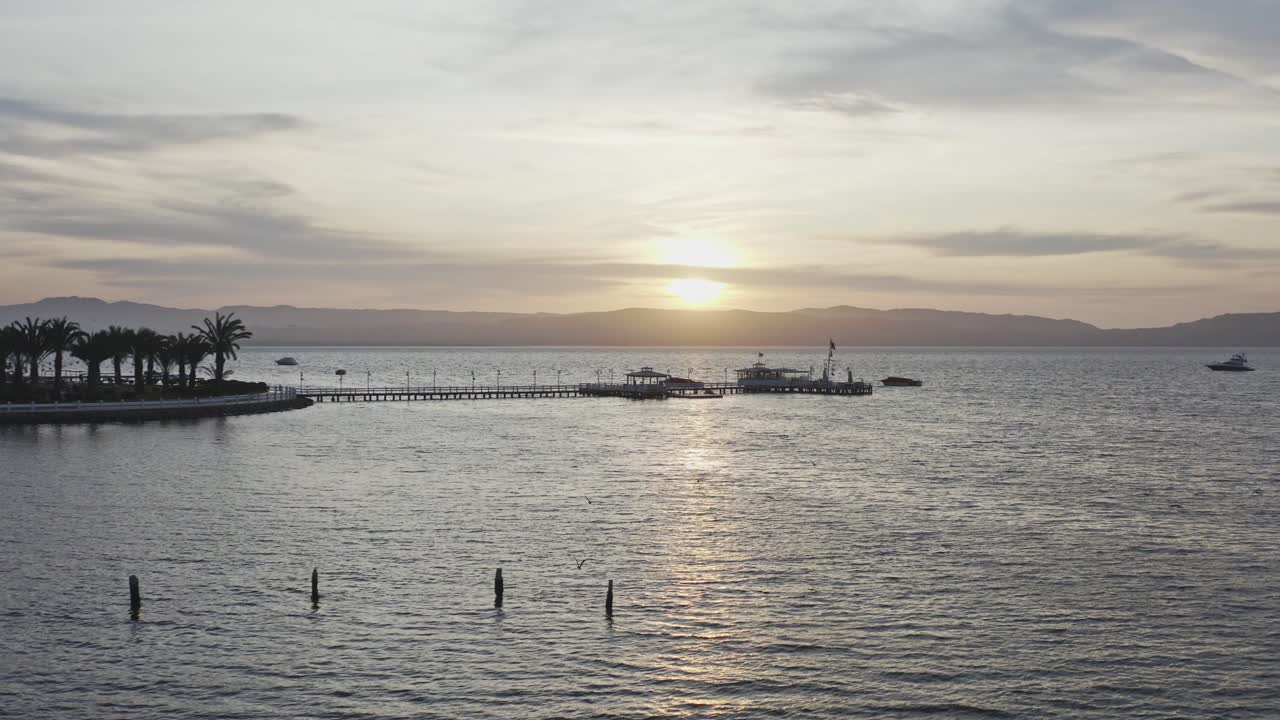 muelle de la bahía de paracas con bandera peruana y paisaje montañoso trevel ica, perú - drone uhd