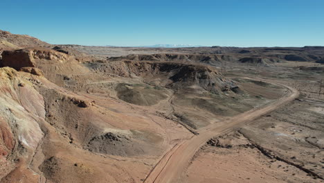 Aerial-View-of-Dirt-Road-and-Sandstone-Hills-in-Utah-Desert-Wilderness-USA-Drone-Shot