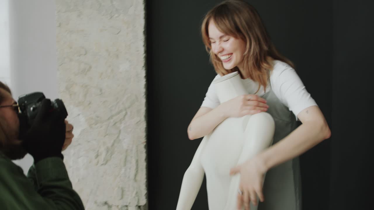 Young Woman Having Fun during Studio Photo Shoot with Mannequin
