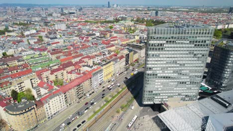 Vienna-skyscraper-and-cityscape-by-wien-hbf-train-station,-sunny-day,-Austria,-aerial