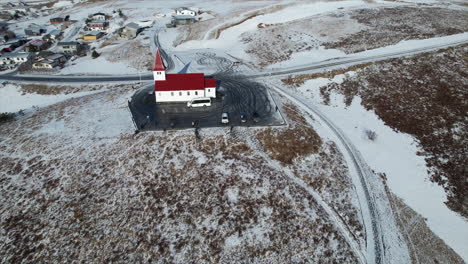 erleben sie islands atemberaubende küstenlandschaft aus einer neuen perspektive, indem sie mit einer drohne die einzigartige architektur einer katholischen kirche inmitten der natürlichen schönheit einfangen