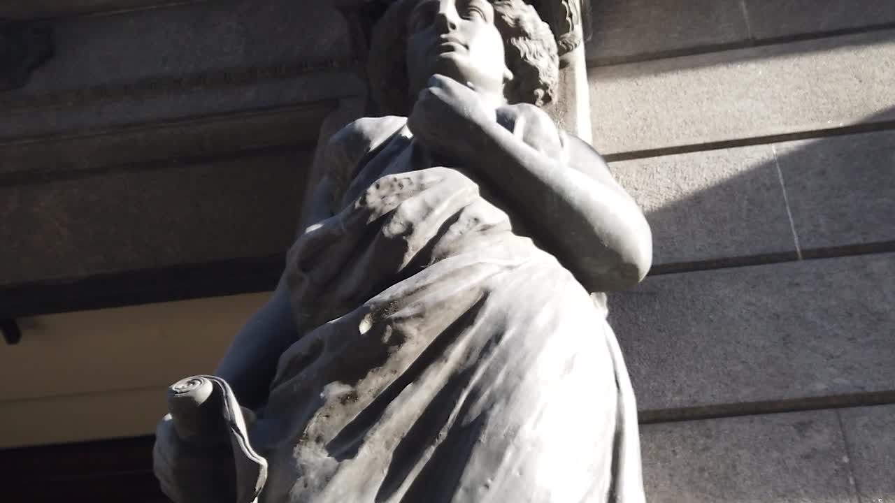 Primer plano de una estatua congresual, conocimiento, sabiduría y justicia, mujeres sosteniendo papiros, contrapicado en Argentina, Buenos Aires.
