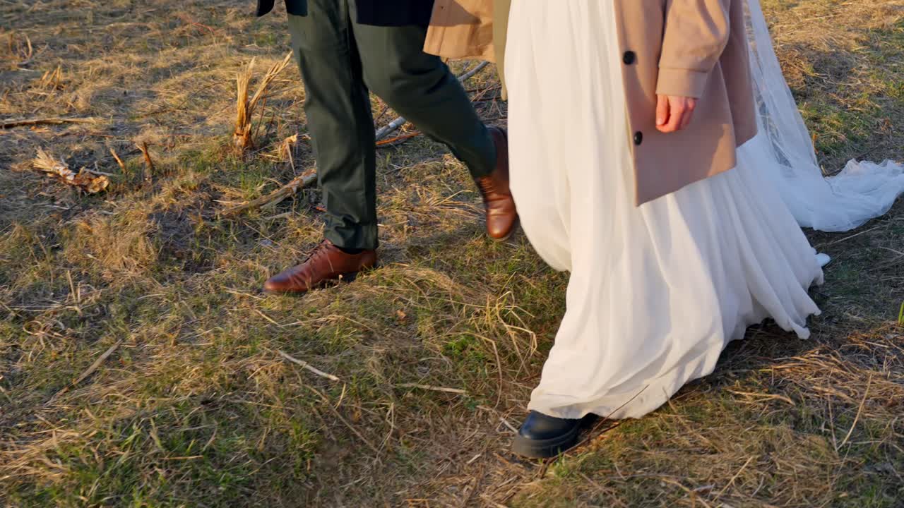 Husband and wife walking on grassy pathway after wedding ceremony