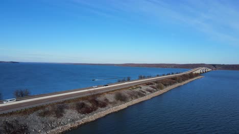 aerial footage of a bridge over water and a speed boat passing by