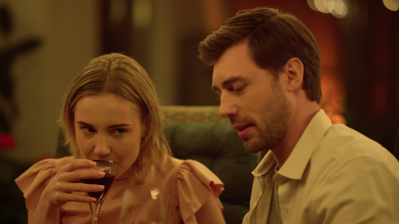 남성과 여성이 테이블에서 와인을 마시고 있다. 긍정적 인 커플이 데이트에서 유혹한다.