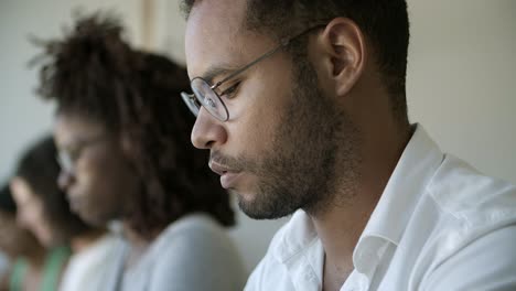 Focused-African-American-man-in-eyeglasses-looking-down