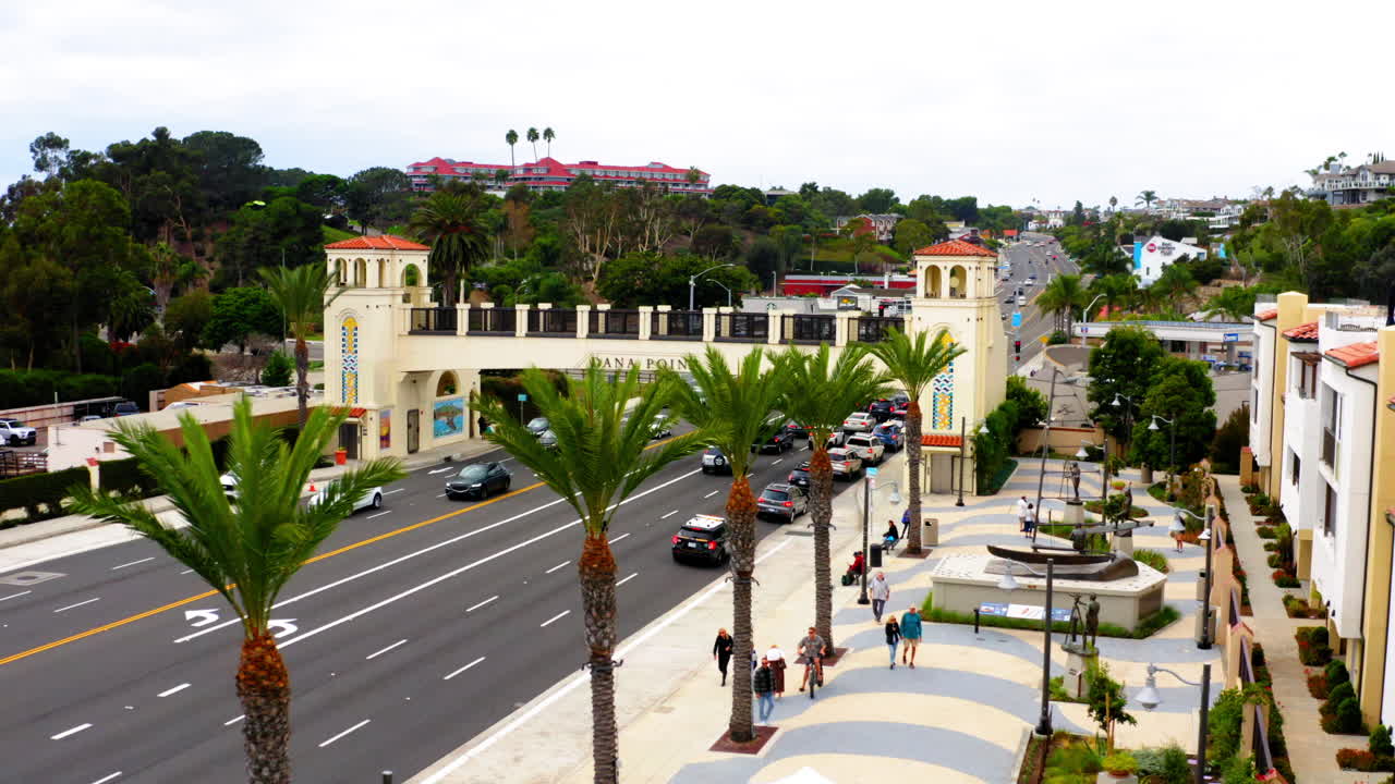 Overhead view of Dana Point archway and Pacific Coast Highway with cars and palm trees