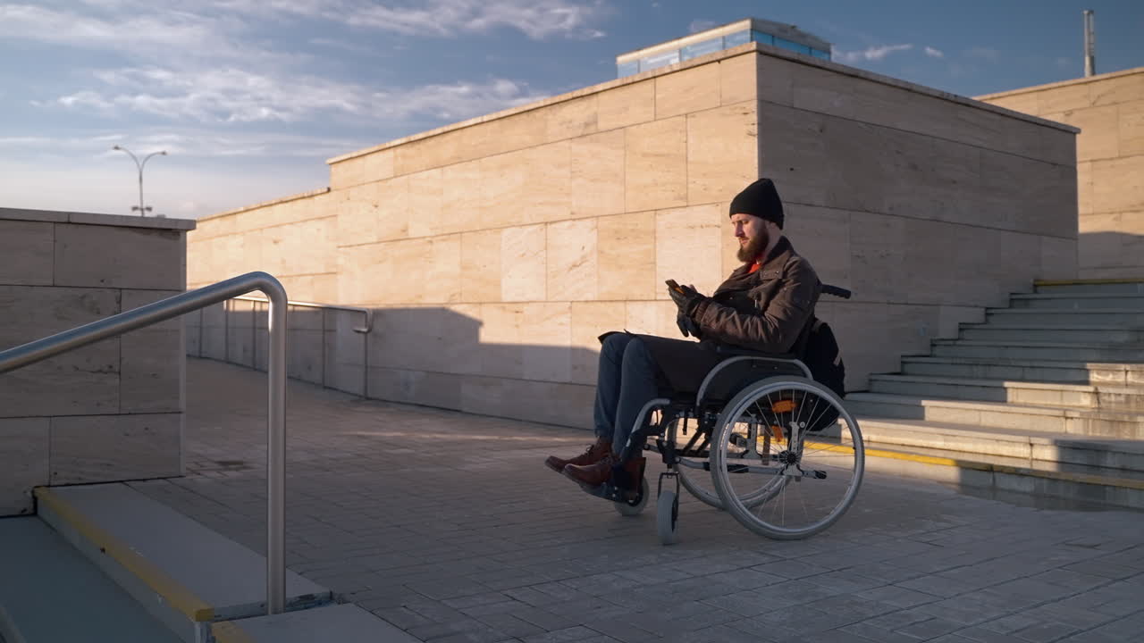 hombre en silla de ruedas usando un teléfono inteligente