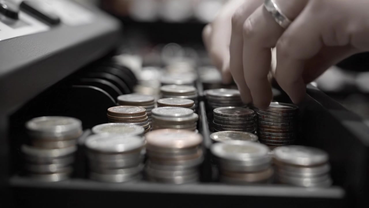 Close-Up Shots of Stacked Coins in a Cash Register Compartment Showcasing Various Denominations and Textures in an Organized Display of Currency Storage