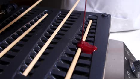 putting red velvet mixture on tree waffle machine