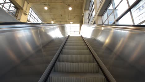 escaleras eléctricas subiendo constantemente hacia un edificio corporativo