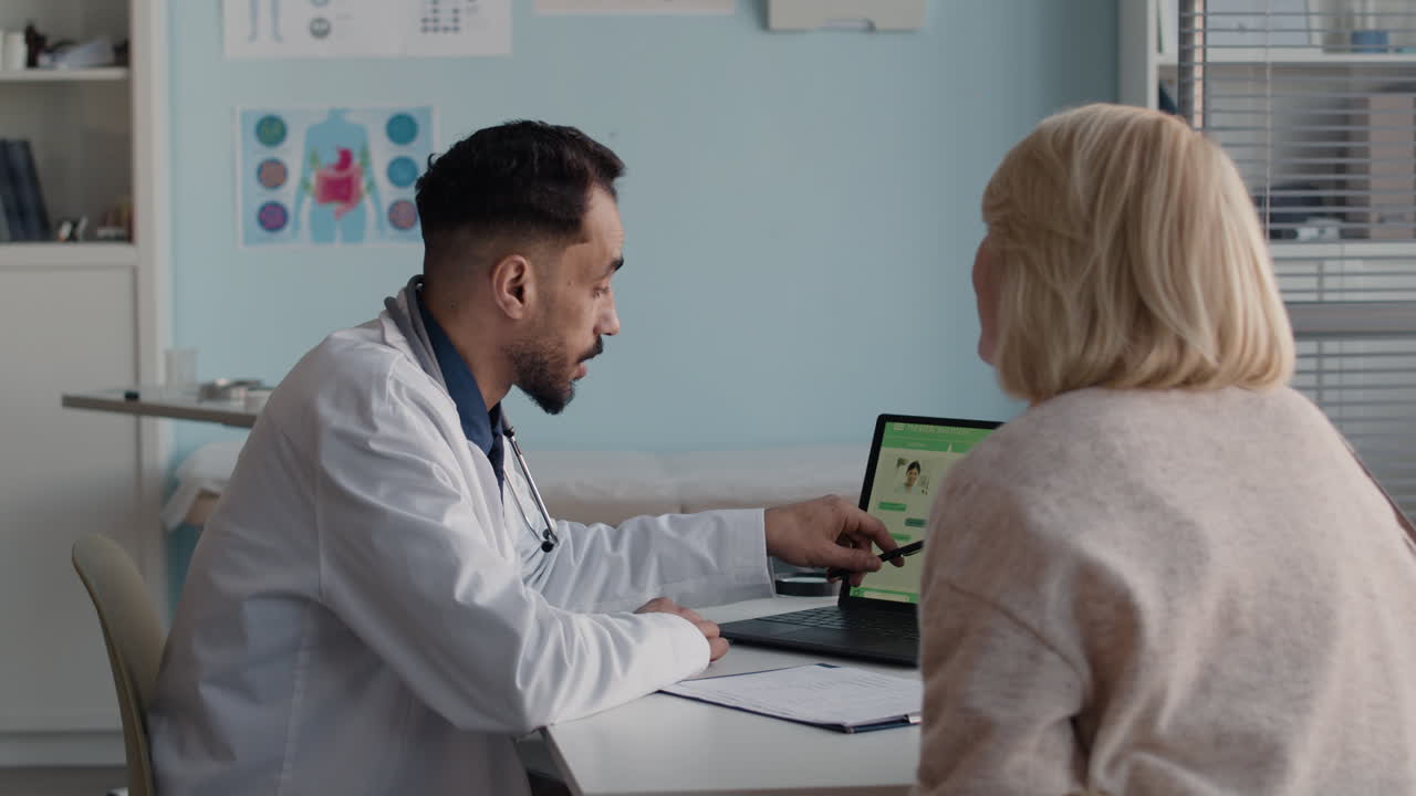 Doctor explaining medical data to patient on laptop
