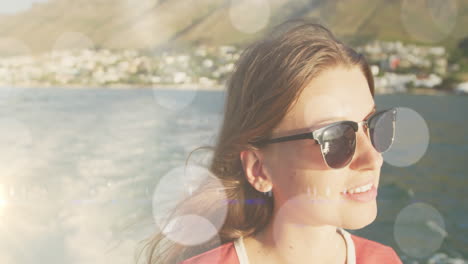 animation of bokeh over caucasian teenager girl wearing glasses and sailing