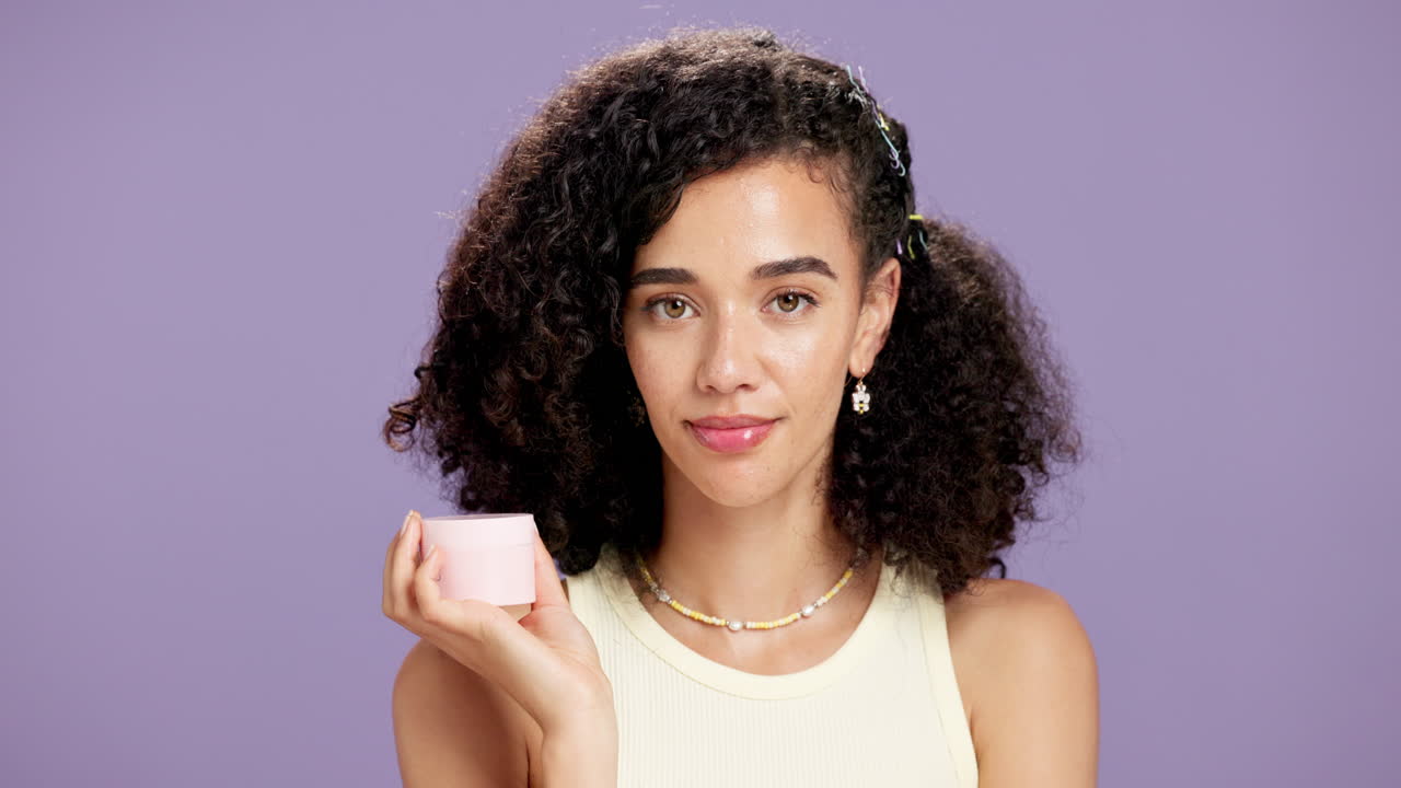 Woman with curly hair holding beauty product