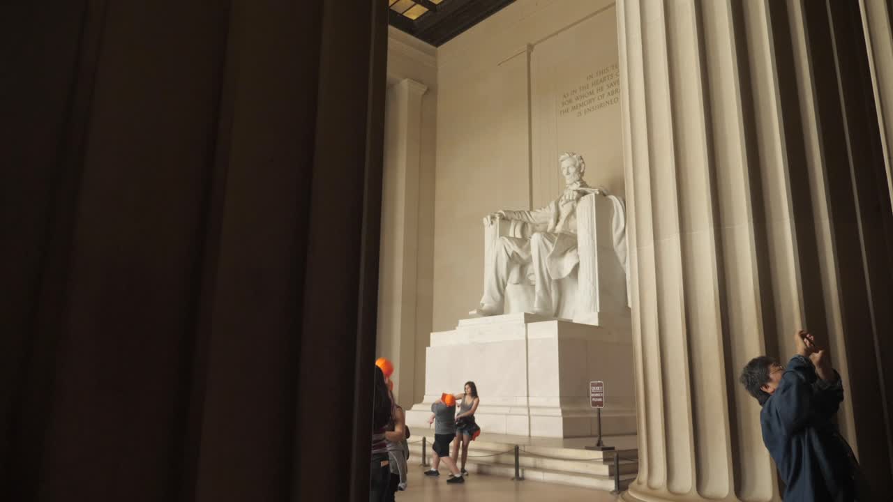 Abraham Lincoln memorial statue inside neoclassical temple, Washington D.C., slow motion pan down reveal