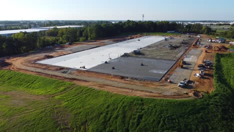 a-wide-angle-orbiting-shot-showing-concrete-being-poured-next-to-a-drying-pad