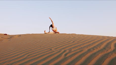 Junge-Brünette-Yogalehrerin-Auf-Einem-Sandhügel,-Die-Während-Der-Goldenen-Stunde-Eine-Morgendliche-Yoga-Routine-Durchführt