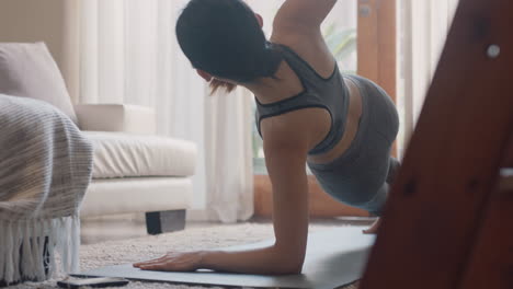 healthy asian woman exercising at home practicing side plank in living room enjoying morning fitness workout